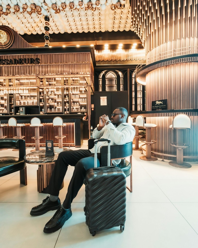 A business traveller waiting with a suitcase in a modern airport lounge